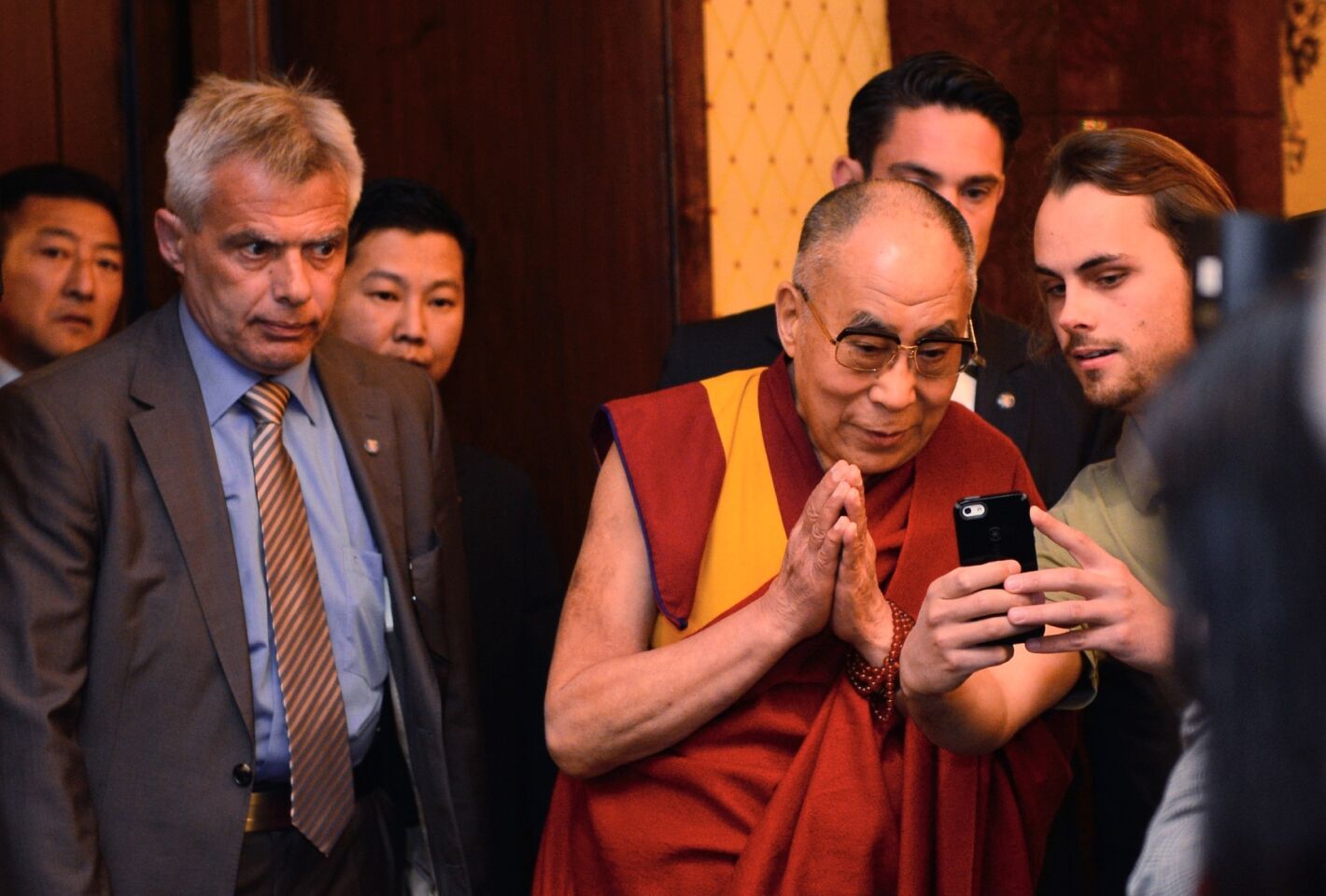A visitor takes a selfie with the Dalai Lama as he arrives for a press conference on May 14, 2014, in Frankfurt, Germany.