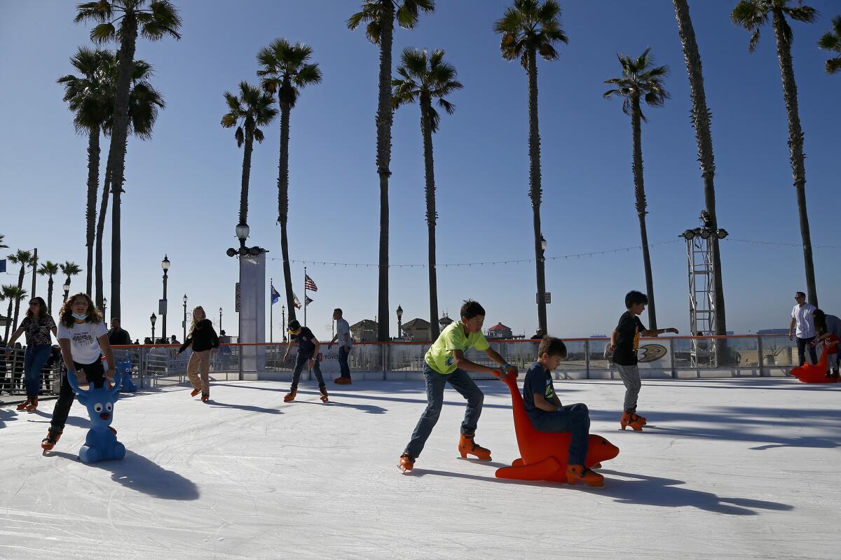 Visitors skate around during a soft opening for the Surf City Winter Wonderland ice skating rink. 
