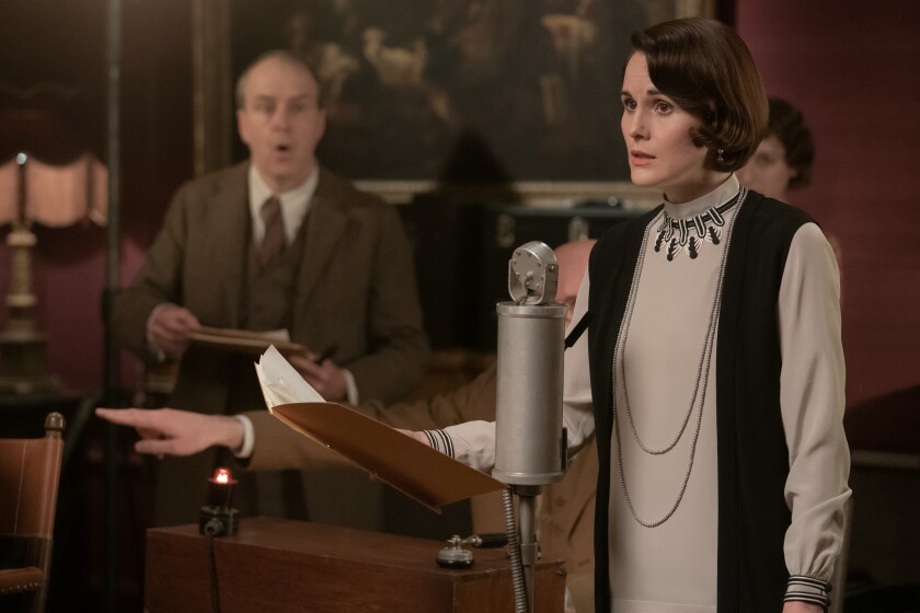 A man in a suit and a woman in an Art Deco dress look surprised.
