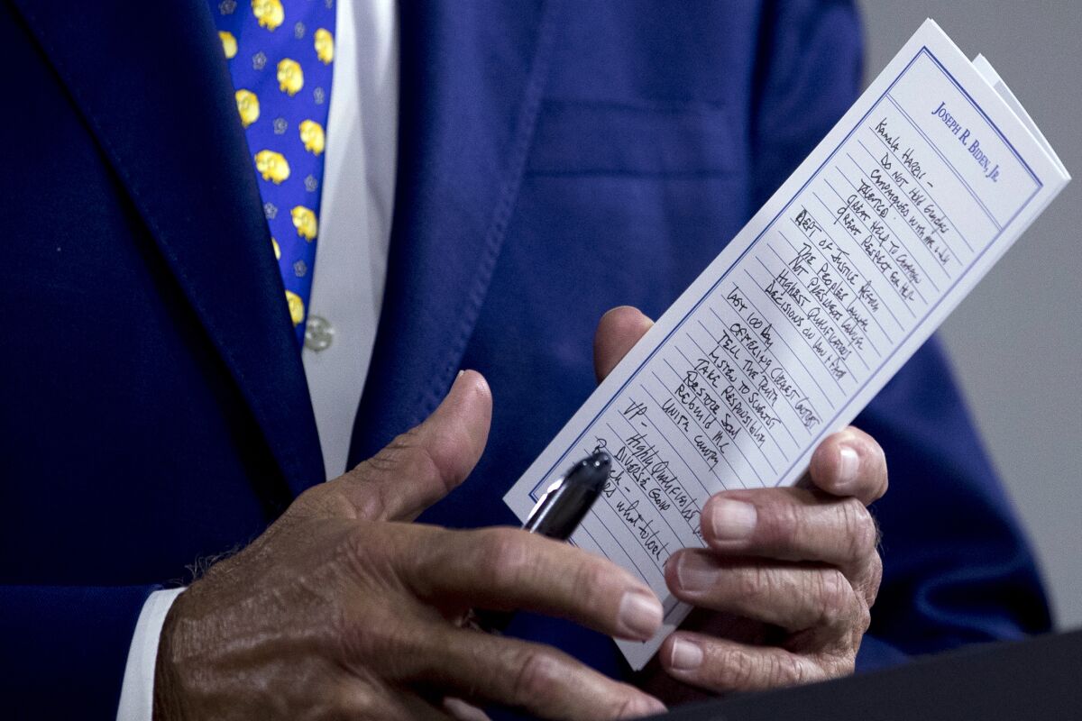 Joe Biden holds notes related to  Sen. Kamala Harris at a campaign event. 