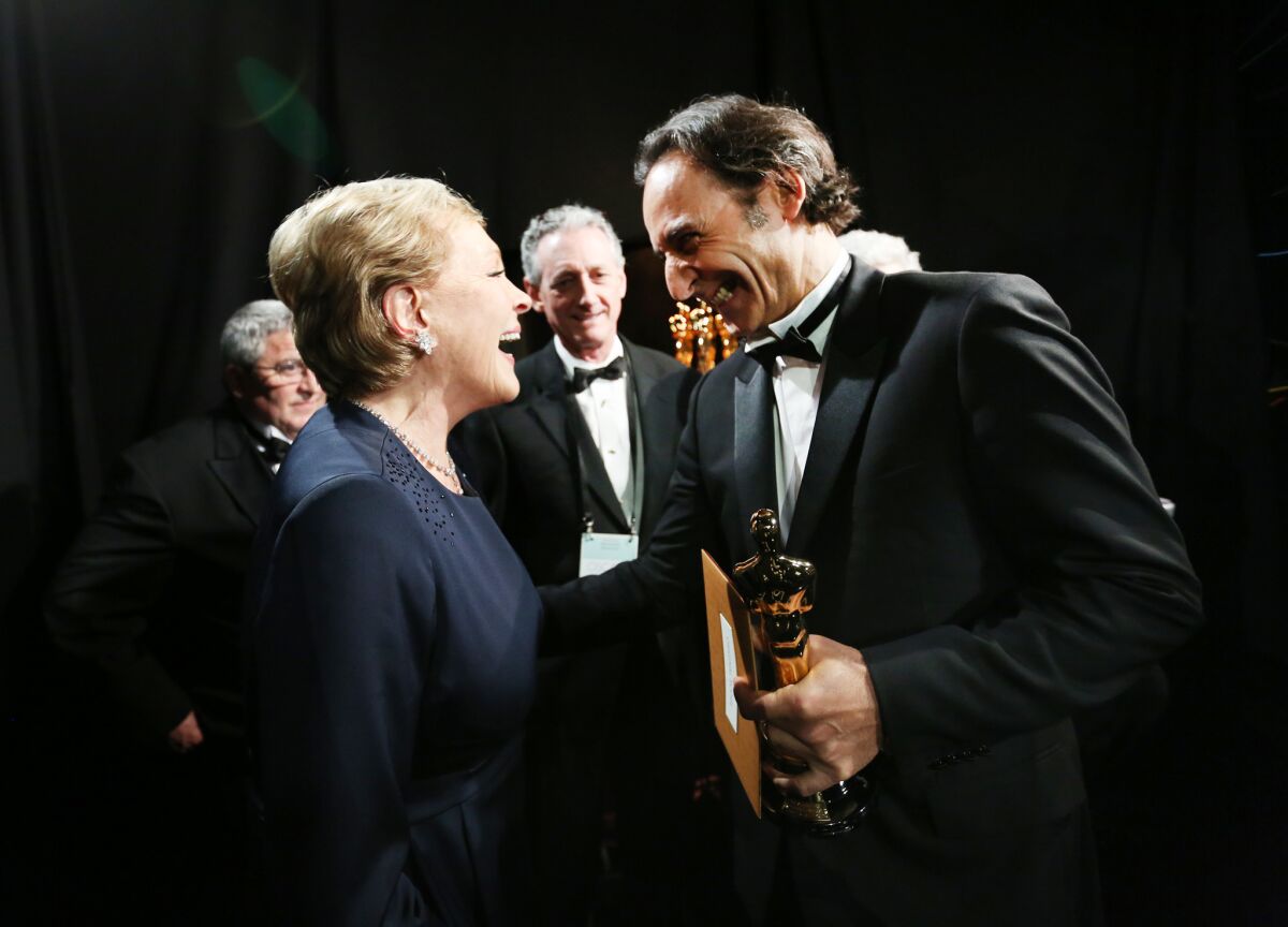 Julie Andrews, left, congratulates Alexandre Desplat on his win for original score for "The Grand Budapest Hotel" backstage at the 87th Academy Awards.