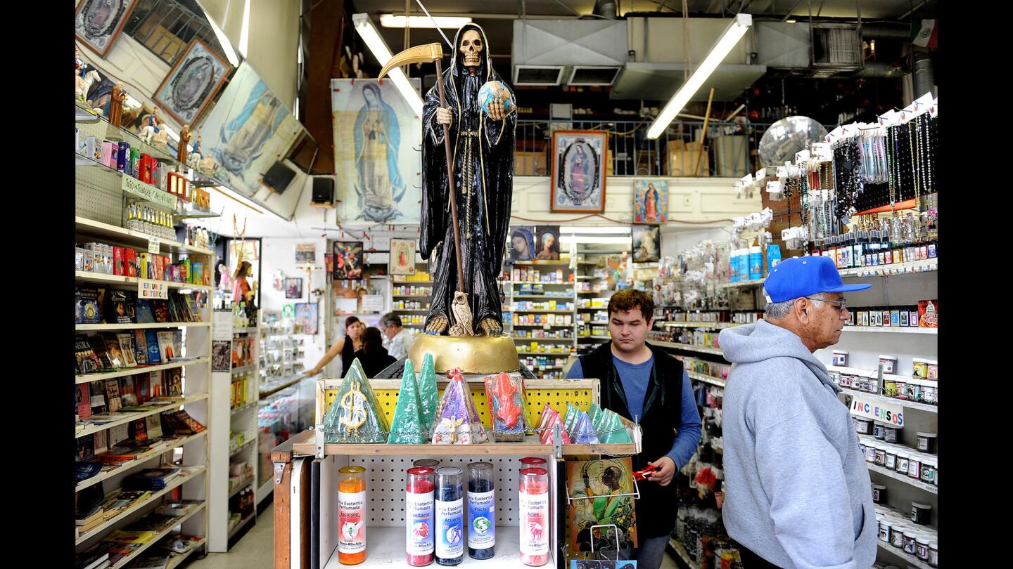 Customers browse inside Farmacia Million Dollar at 3rd Street and Broadway in downtown Los Angeles. The shop sells candles, sprays and herbs that will help open new paths, find you the love of your life or bring you good luck.