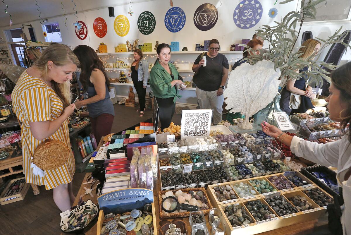 Guests shop for metaphysical items Wednesday at a summer solstice celebration at Laguna Beach's Chakra Shack.
