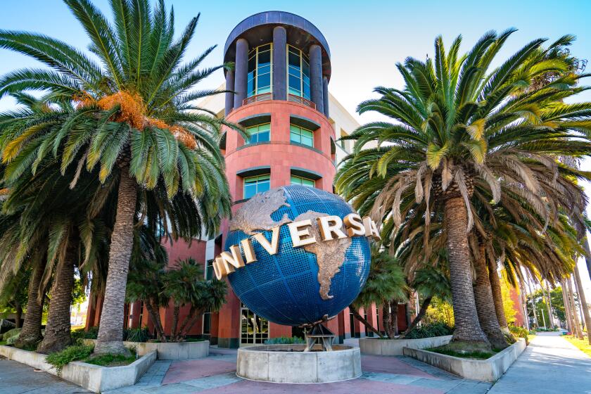 A globe fountain and palm trees decorate the entrance to the Universal Music Group office.