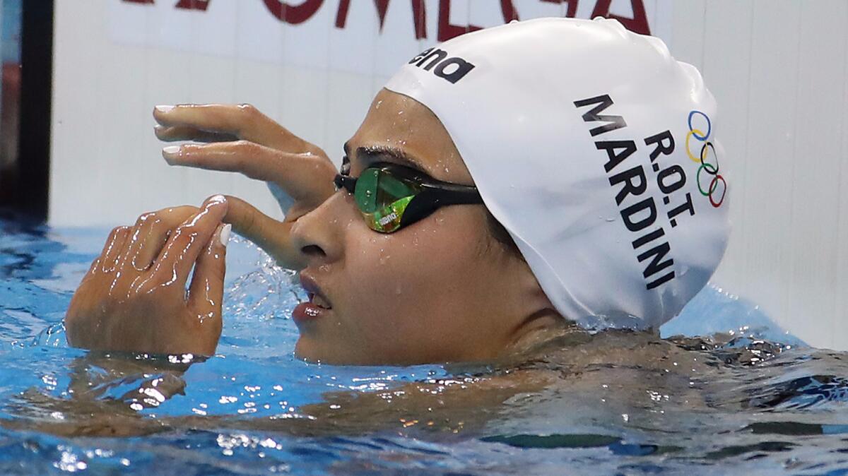 Yusra Mardini checks the scoreboard after winning a preliminary heat in the women's 100-meter butterfly on Saturday in Rio de Janeiro.
