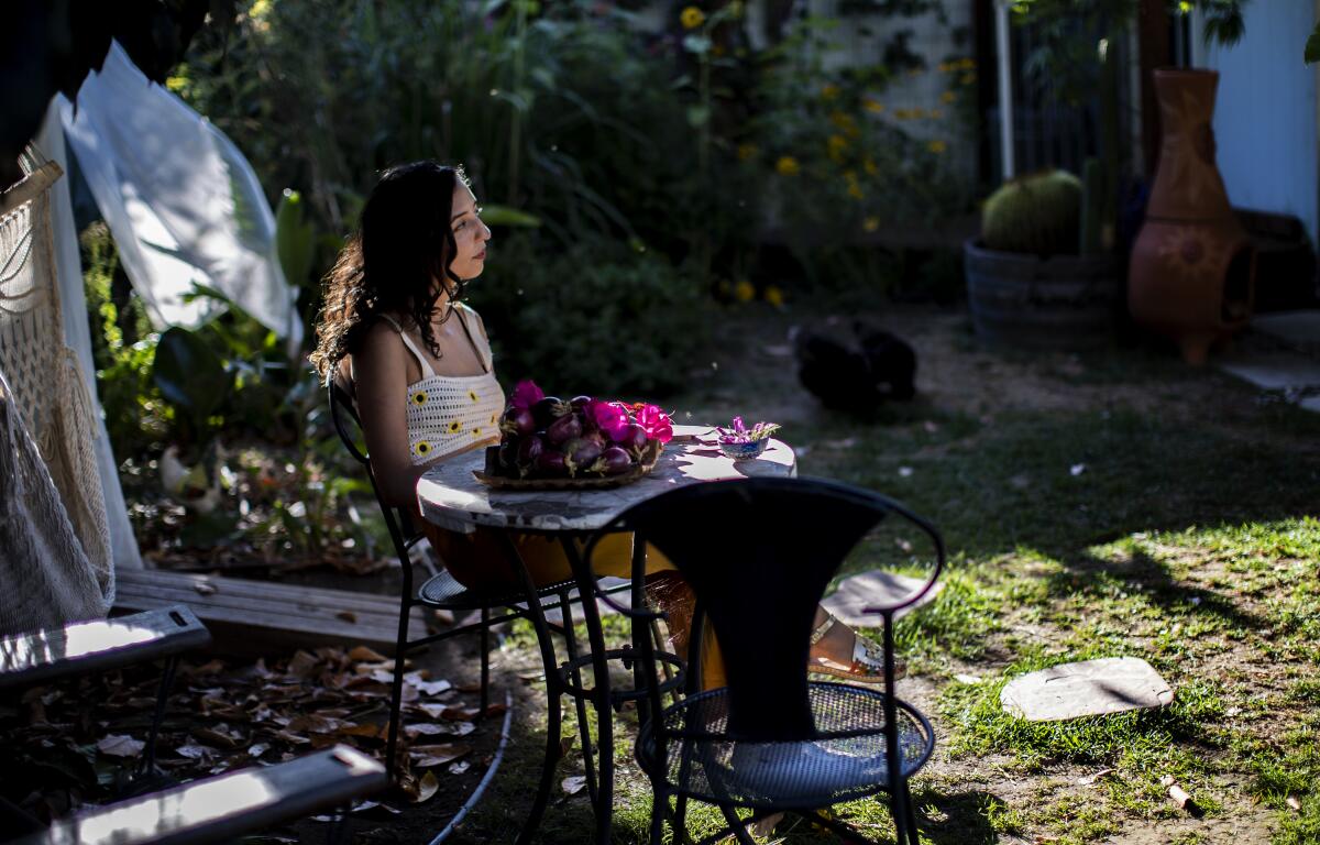 Vaziri sits in her backyard garden next to a bowl of homegrown passion fruit.