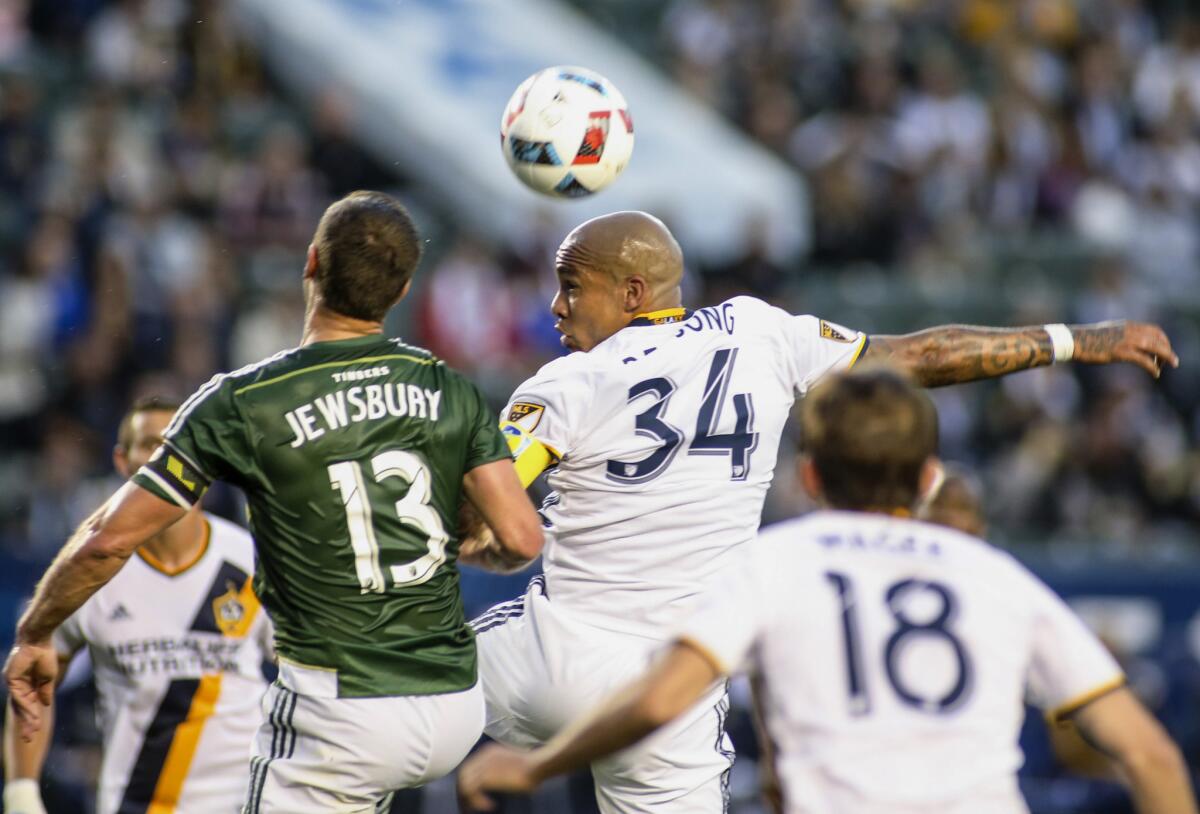 Galaxy midfielder Nigel de Jong (34) heads the ball against Timbers defender Jack Jewsbury during the first half.