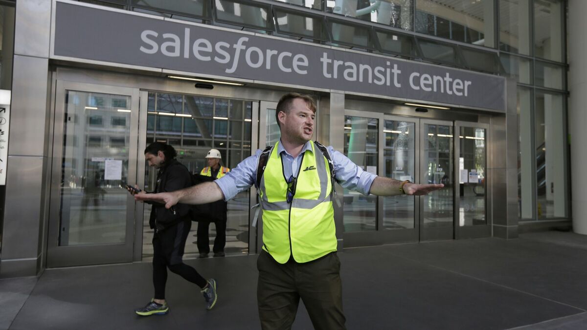 Mike Eshleman, with AC Transit, directs people away from San Francisco's Salesforce Transit Center after it was closed Tuesday when a crack was discovered in a support beam.