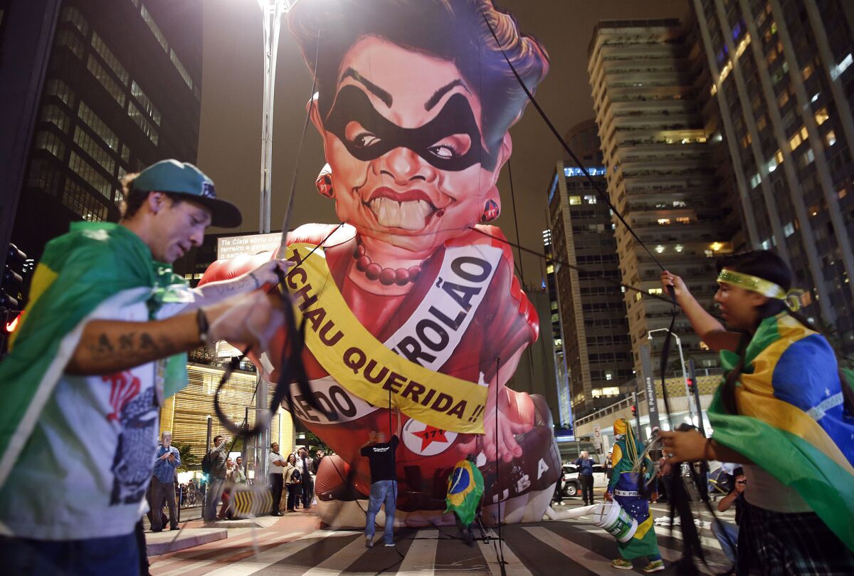 Demonstrators set up an inflatable caricature of Brazil's President Dilma Rousseff wearing sashes reading "Goodbye dear" and "Mother of Big Oil" in Portuguese in Sao Paulo on May 11.