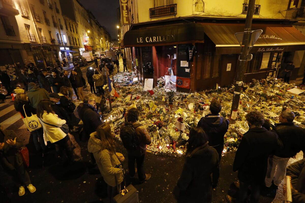 People gather at a makeshift memorial to the victims of the deadly attacks in Paris on Nov. 20. French President Francois Hollande plans to visit Washington asking for U.S. help, increasing the pressure on Obama to do more.