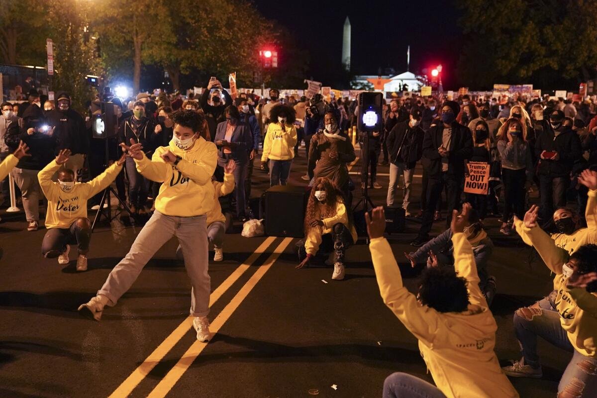 A dance group entertains people gathered outside the White House while awaiting election results in Washington.