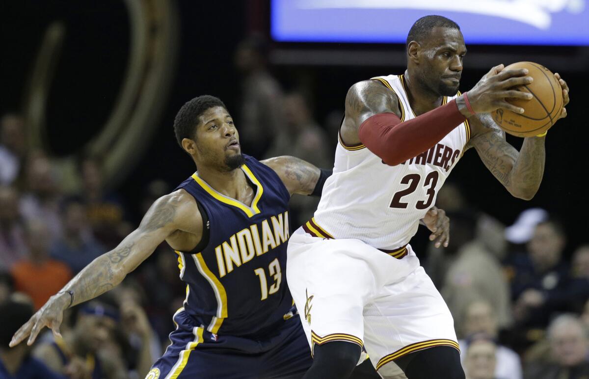 Pacers forward Paul George (13) keeps a close watch on Cavaliers forward LeBron James (23) during the first half.