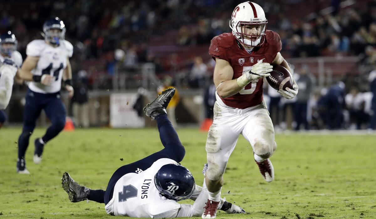 Stanford running back Christian McCaffrey runs past Rice linebacker Alex Lyons on a 23-yard touchdown reception Nov. 26.