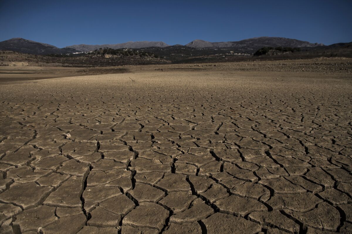 Part of the Vinuela reservoir is seen dry and cracked due to lack of rain in La Vinuela, southern Spain, Feb. 22, 2022. Declining agricultural yields in Europe, and the battle for diminishing water resources, especially in the southern part of the continent, are key risks as global temperatures continue to rise. These conclusions are part of a new United Nations report that will help countries decide how to prevent the planet from warming further. (AP Photo/Carlos Gil)