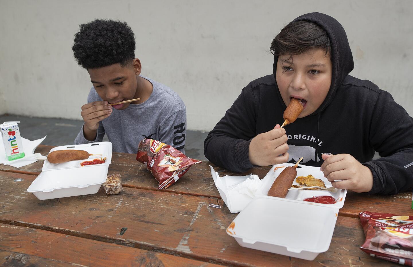 Camino Nuevo Charter Academy students eat corn dogs