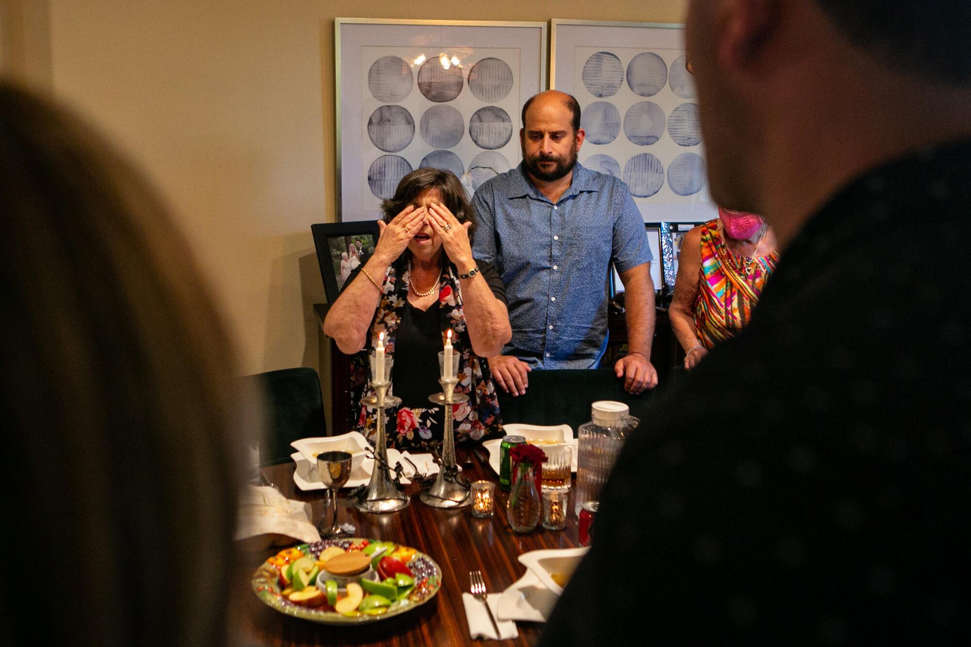 Pamela Taylor, an evacuee of the Caldor fire in South Lake Tahoe, recites a blessing in Hebrew at Rosh Hashanah dinner.