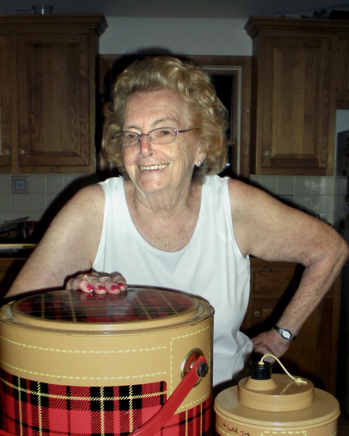 Woman grins with her hand on her hip in a kitchen