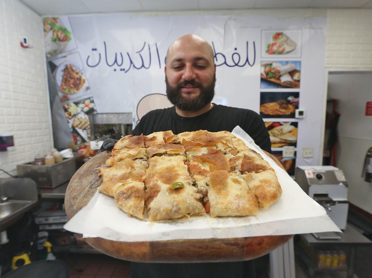 Chef Sam Zarzour holds a beef shawerma pie at the Feteer Guy in Huntington Beach.