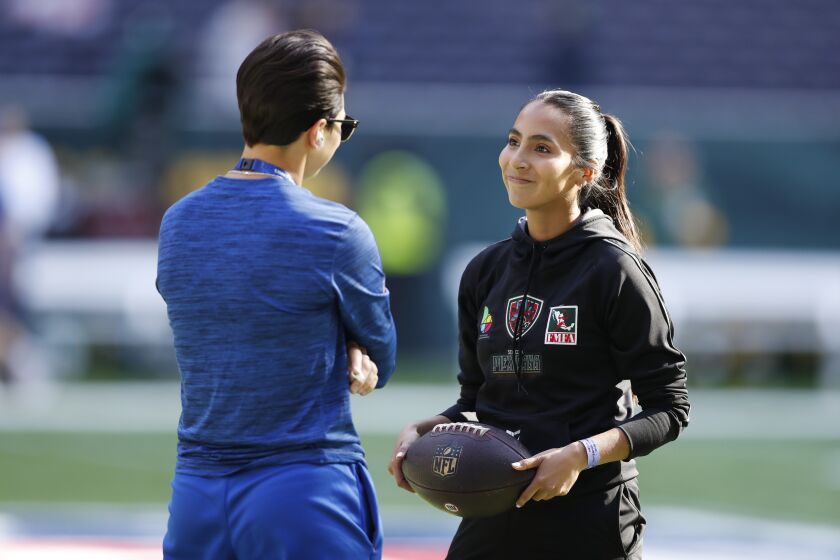 Team Mexico Women's Flag quarterback Diana Flores speaks with New York Giants offensive quality control coach Angela Baker before an NFL football game between the Green Bay Packers and the New York Giants at Tottenham Hotspur Stadium in London, Sunday, Oct. 9, 2022. The New York Giants won 27-22. (AP Photo/Steve Luciano)