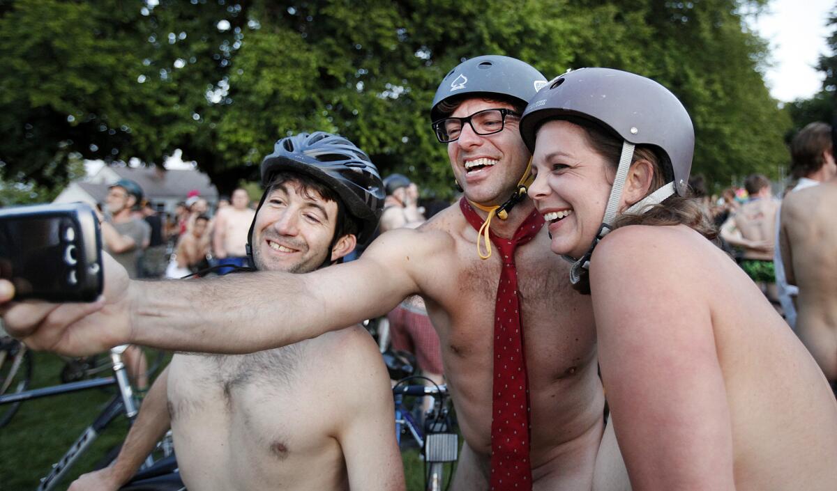 Cyclists (from left) Randy Rodriguez, Chris Lynch and Mary Cadien take a "selfie" wearing only a tie as they join thousands of others at Normandale Park in Portland, Ore., on Saturday for the 11th annual World Naked Bike Ride.