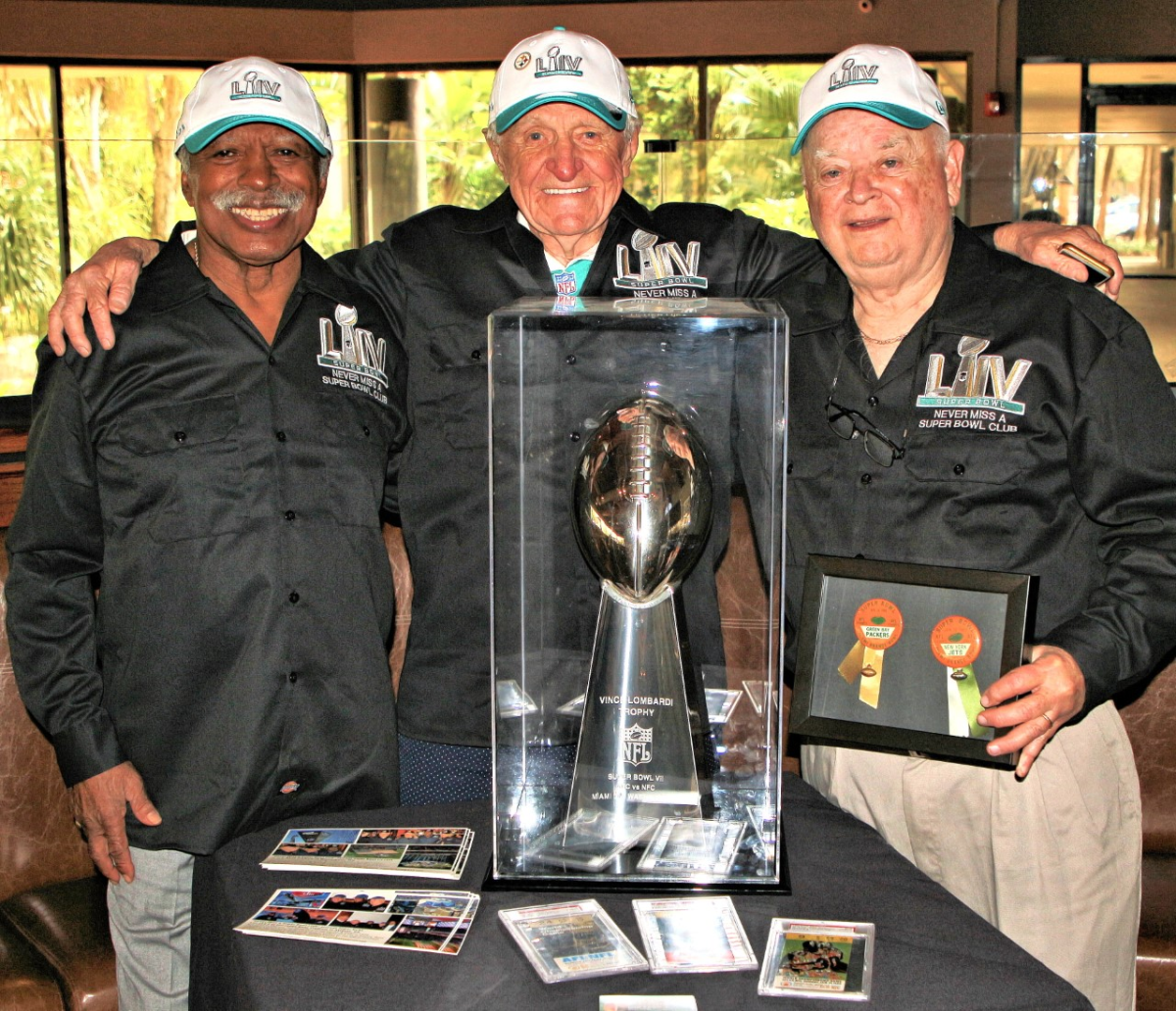 From left to right: Gregory Eaton, Tom Henschel and Don Crisman pose with a replica of the Vince Lombardi Trophy.