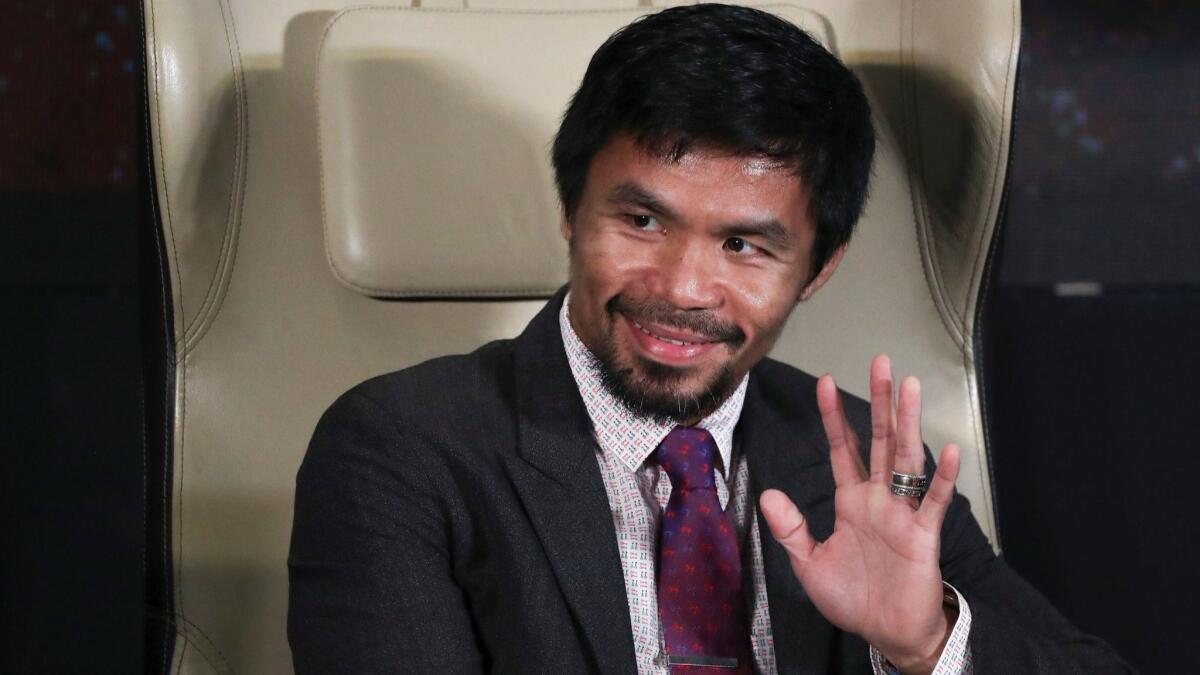 Manny Pacquiao waves to son Israel during a press conference in Kuala Lumpur, Malaysia, on Thursday.
