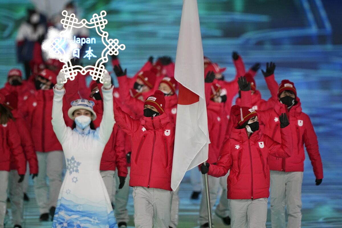 Arisa Go and Akito Watabe, of Japan, lead their team in during the opening ceremony of the 2022 Winter Olympics, Friday, Feb. 4, 2022, in Beijing. (AP Photo/David J. Phillip)