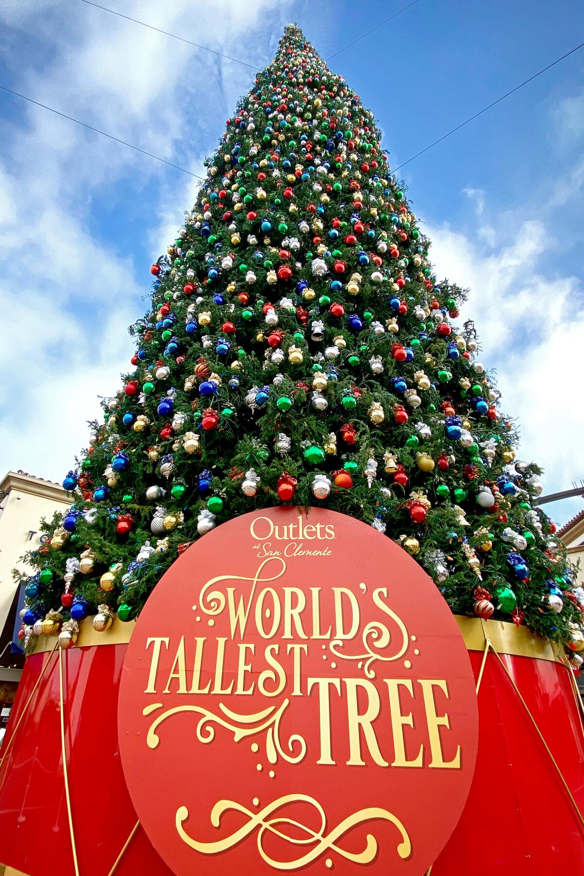 A view of the ornament-covered tree looking up from its base; a sign says "World's tallest tree."