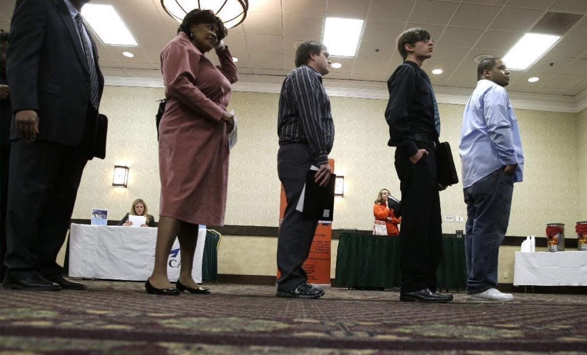 Job seekers line up to meet a prospective employer at a career fair at a hotel in Dallas.