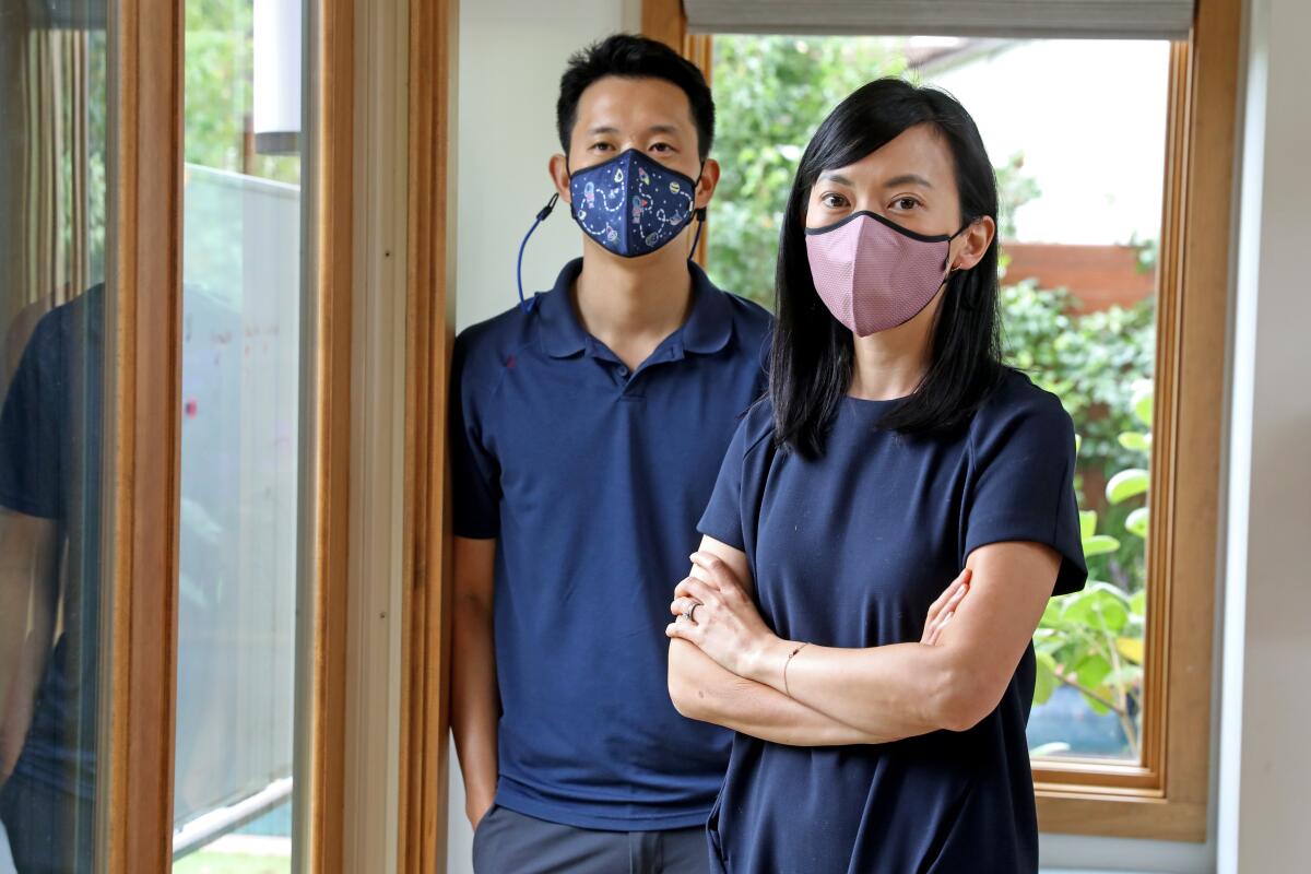 Happy Masks founders Melinda Hwang and husband Ed Fu model their company’s face coverings.