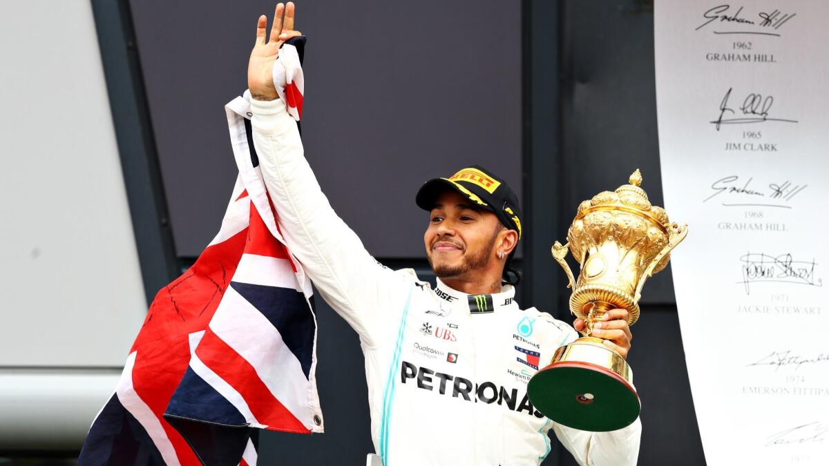 Formula One driver Lewis Hamilton celebrates on the podium after capturing his sixth victory in the British Grand Prix at Silverstone on Sunday.