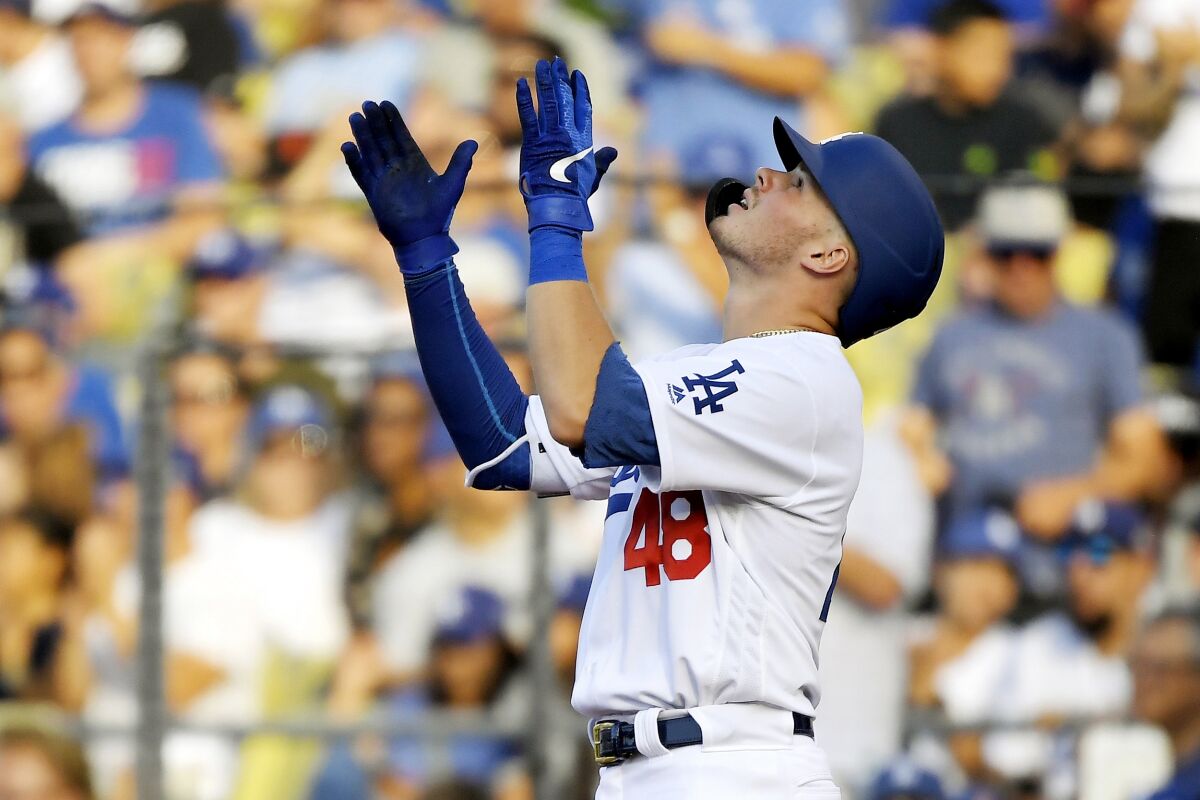 Dodgers second baseman Gavin Lux claps after hitting a single against the Colorado Rockies on Monday.
