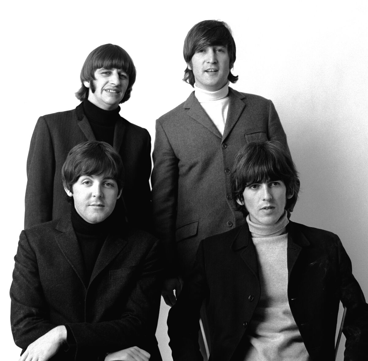 A rock band in the 1960s posed in a black-and-white photo