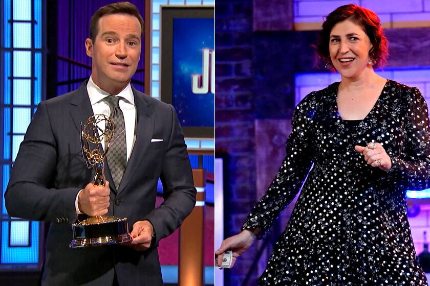 A man holding an Emmy, left, and a woman in a polka-dot dress
