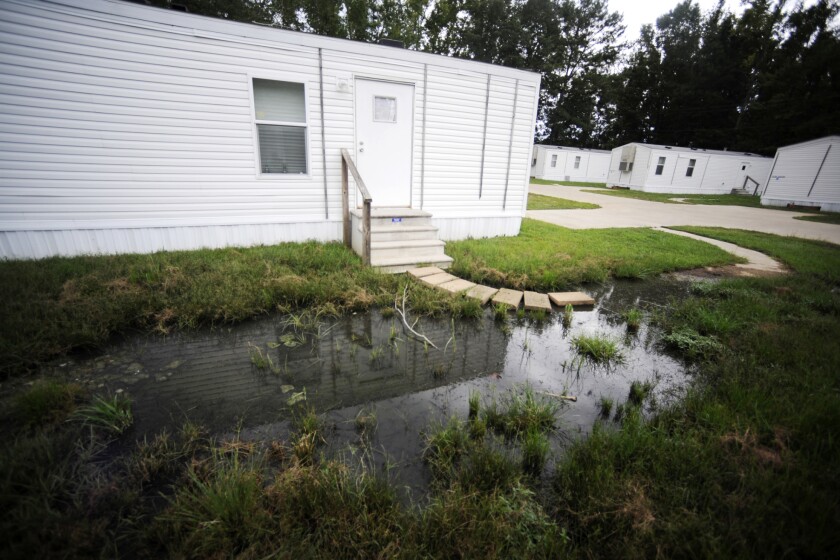 Fetid water stands outside a mobile home in a small mobile home park in rural Hayneville, Ala., on Monday, Aug. 1, 2022. The government announced a pilot program on Tuesday to help rural communities that face serious sewage problems like those in Lowndes County, where Hayneville is located. (AP Photo/Jay Reeves)