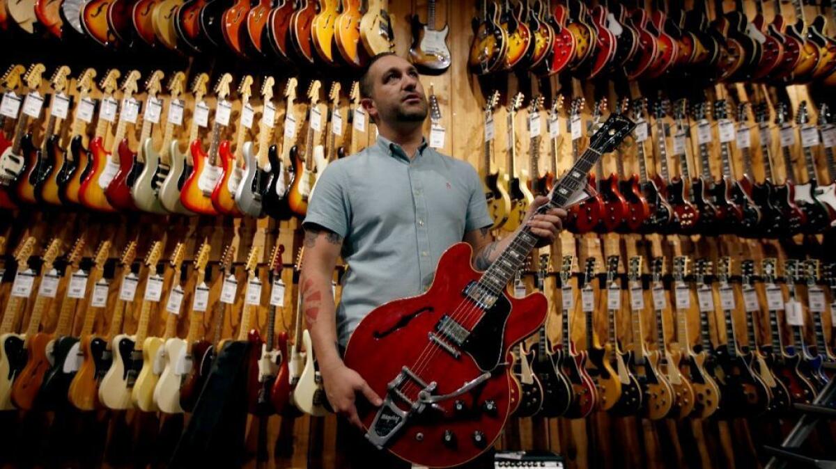 Patrick Carpenter, 33, store director of the Guitar Center in Hollywood, holds a Gibson ES-335, which is similar to the instrument Chuck Berry favored.