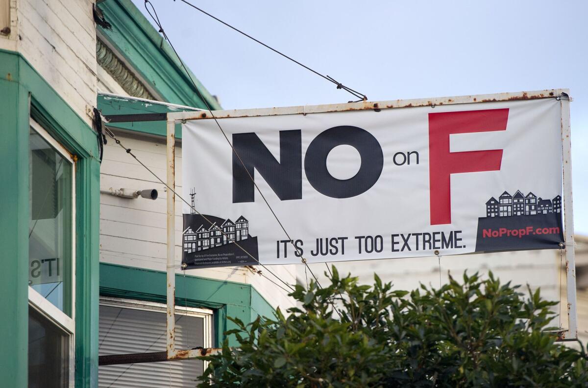 A sign showing opposition to Proposition F is hoisted over a shop in San Francisco on November 2.