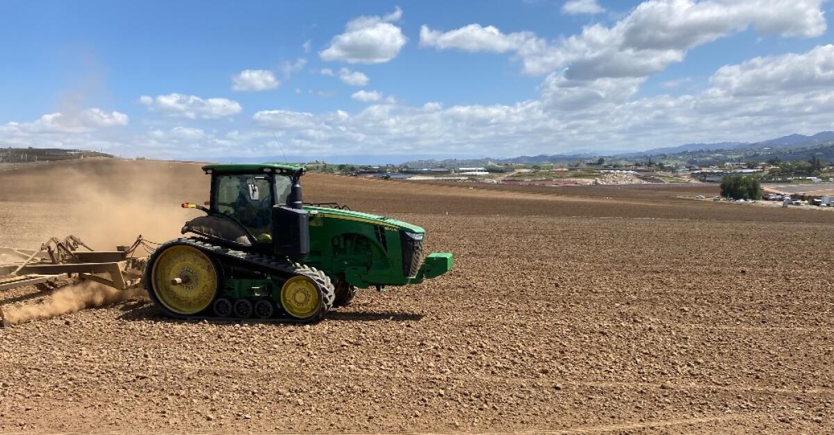 A tractor prepares a field for planting in northeast Oceanside in March 2021.