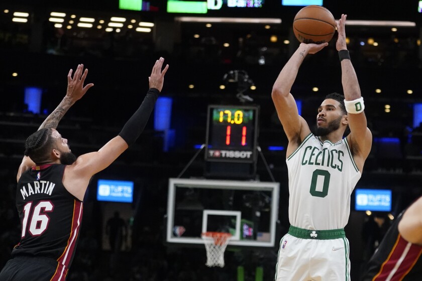 El alero de los Celtics de Boston Jayson Tatum lanza sobre el alero del Heat de Miami Caleb Martin