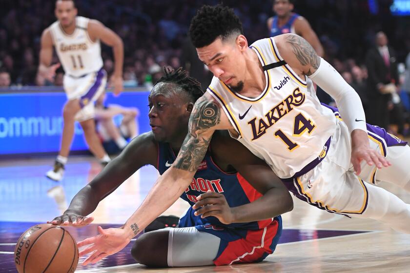 LOS ANGELES, CALIFORNIA JANUARY 5, 2020-Lakers Danny Green and Pistons Sekou Doumbouya battle for a loose ball in the 2nd quarter at the Staples Center Sunday. (Wally Skalij/Los Angerles Times)