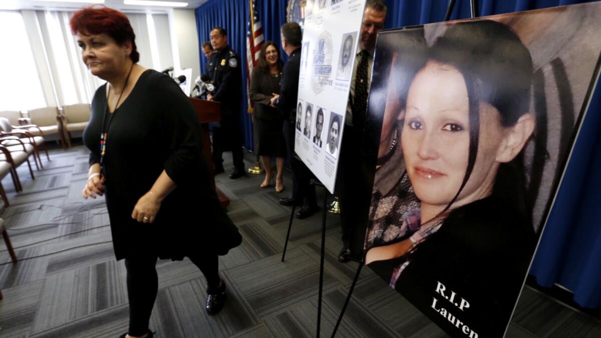Gerilyn Olguin, mother of Lauren Olguin, walks past her photo at the conclusion of a press conference at the FBI Los Angeles field office regarding Sunday's arrest of fugitive Philip Patrick Policarpio, who was charged with murder in her shooting death.