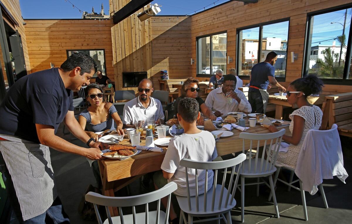 Ignacio Rios, left, serves sand dabs to customers on the Dockside patio.