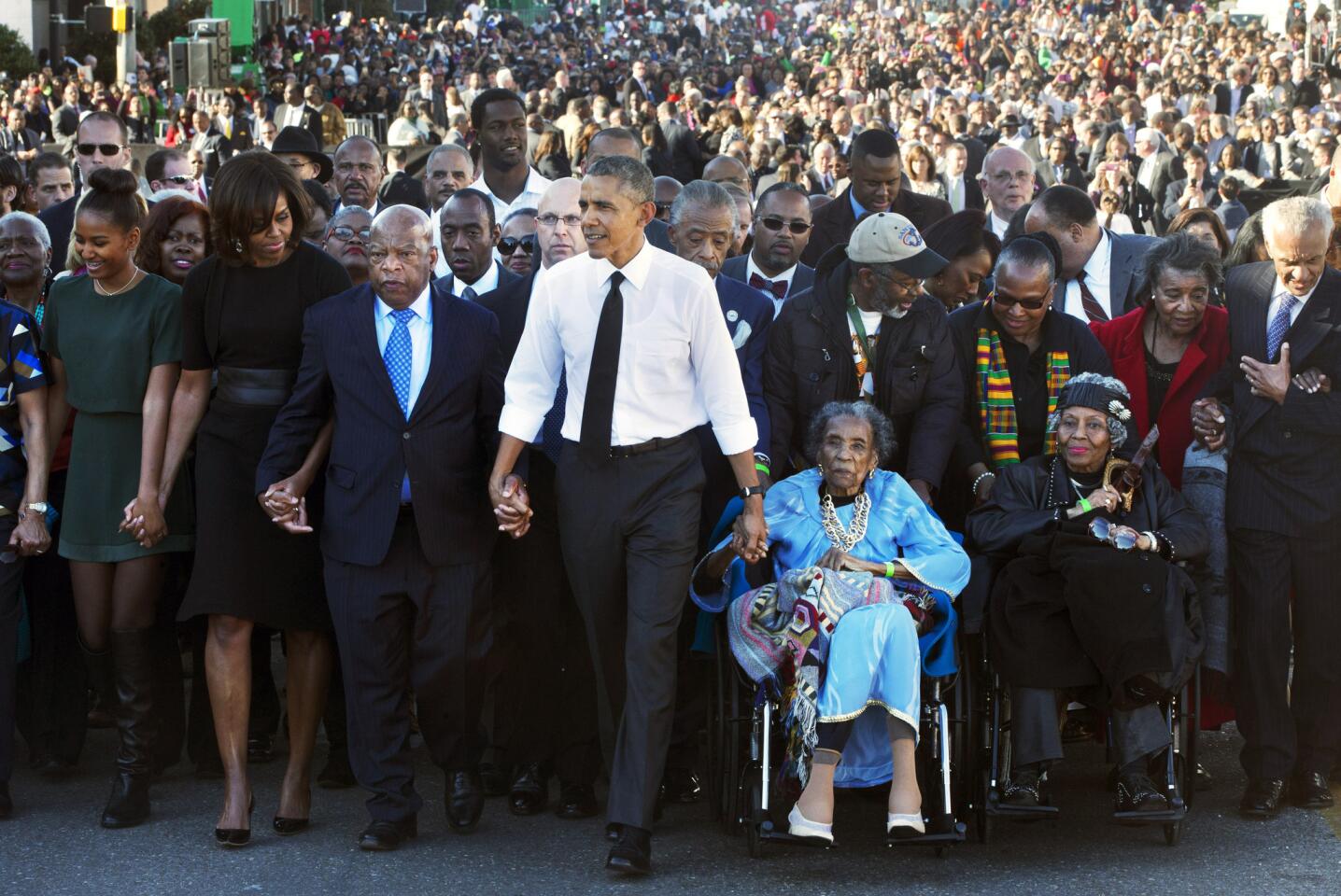 John Lewis holds hands with President Obama and other activists leading a 50th anniversary march in Selma, Alabama