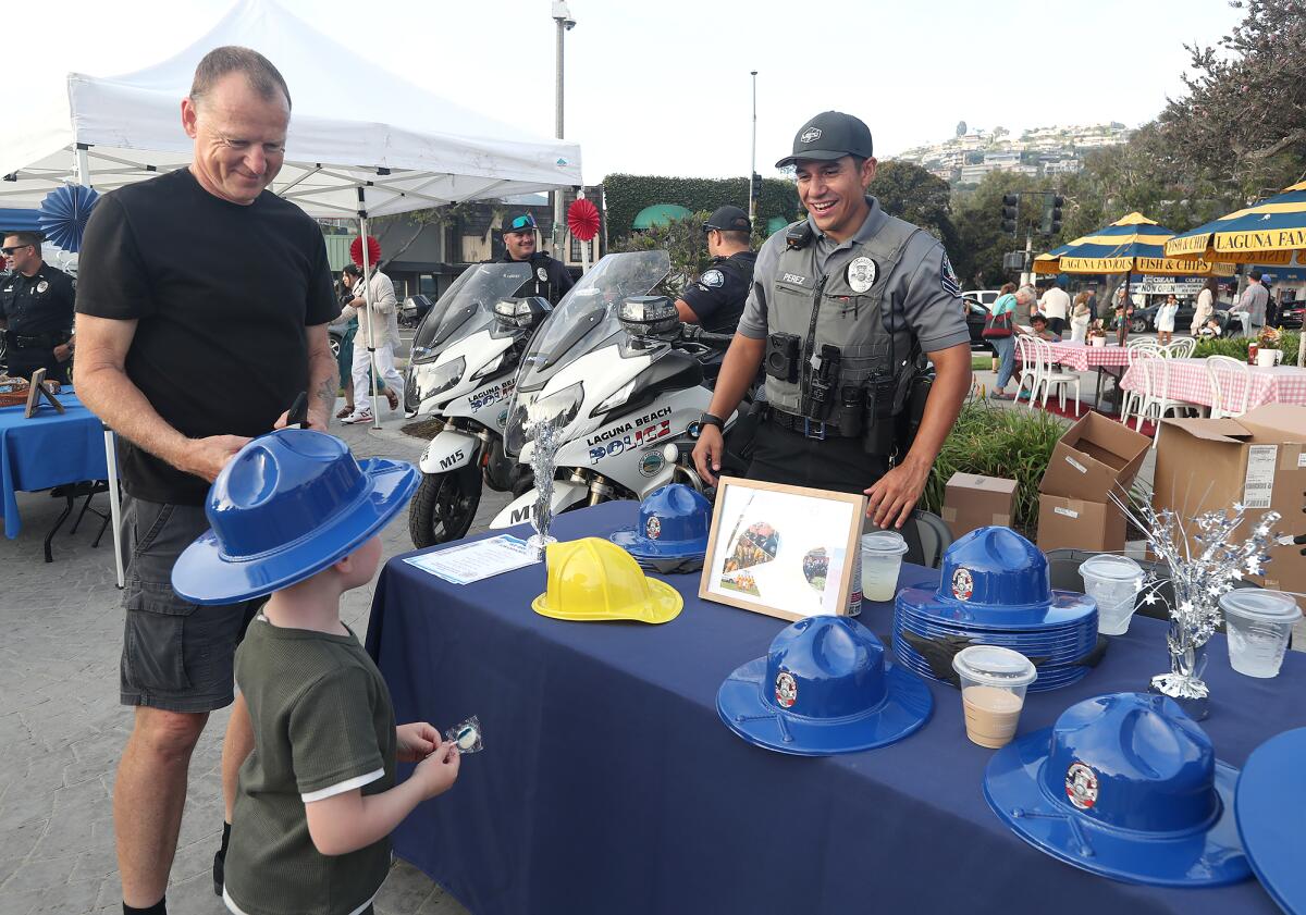 Park Ranger Oscar Perez hands out ranger hats to families during National Night Out.