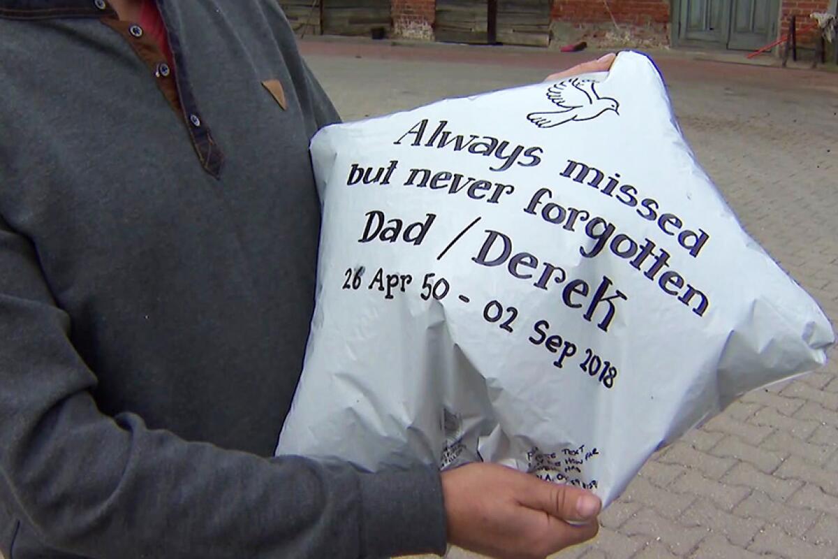 A man holds a helium balloon that landed near his home in Troszkowo, northeast Poland. The balloon was released in Birmingham, England, as a tribute to Nicola Bowler's late father.