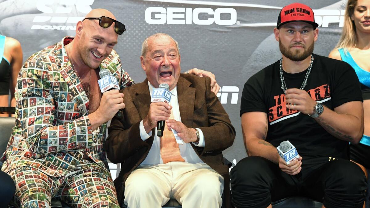 Tyson Fury, left, shares a laugh with promoter Bob Arum while on stage with Tom Schwarz during a news conference at the MGM Grand on Wednesday.