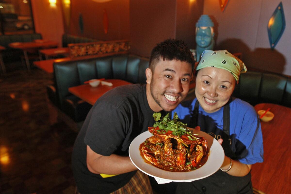 Nguyen Tran and his wife/chef Thi Tran of Starry Kitchen hold a dish of Singaporean chili crab. Starry Kitchen will have an all-you-can-eat crab event Tuesday.