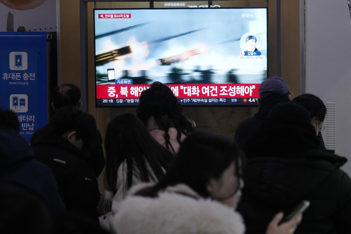 A TV screen shows a file image of North Korea's military exercise 