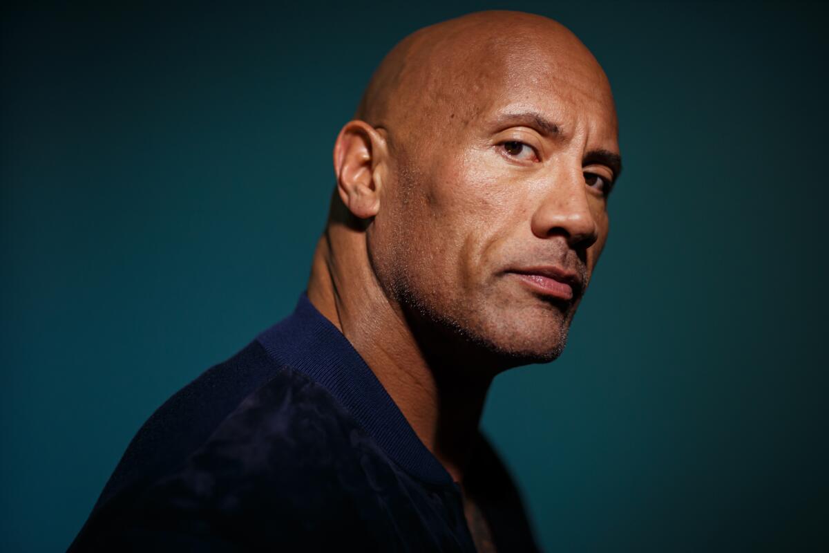 A man with a shaved head poses for a portrait.