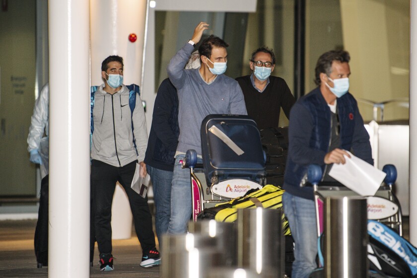 Spain's Rafael Nadal, center, arrives at Adelaide Airport ahead of the Australian Open tennis championship, Adelaide, Australia, Thursday, Jan. 14, 2021. Arriving players will serve a 14-day quarantine period ahead of the first Grand slam tennis tournament that is set to get underway on February 8 in Melbourne. (Morgan Sette/AAP Image via AP)